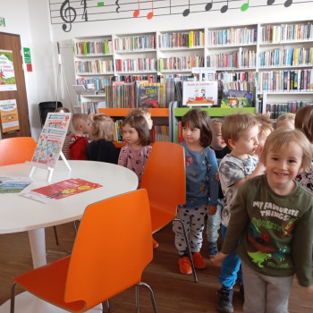 Dzieci w sali w bibliotece.
Z tyłu regały z książkami.