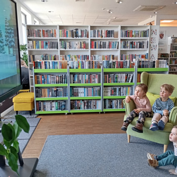 dzieci oglądaja film w sali bibliotecznej
