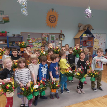 Dzieci stoją i prezentują zrobione przez siebie koszyczki.